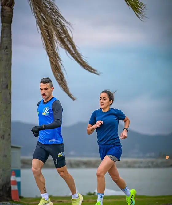 Izaias Vidal acompanhando uma aluna durante um teste de corrida na orla