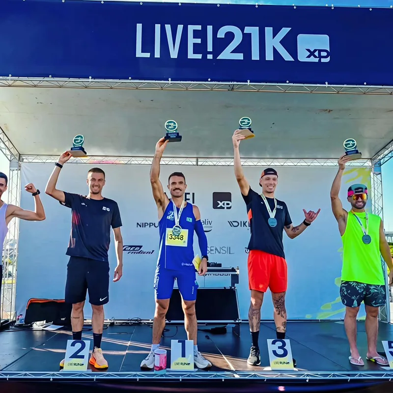 Izaias Vidal no degrau mais alto do pódio da Live! 21K, erguendo o troféu